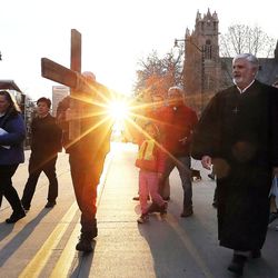 Alex Bury, left, Juliana Snow and the Rev. Eun-sang Lee of the First United Methodist Church carry the cross as it leaves the First Presbyterian Church during the Good Friday Procession of the Cross in Salt Lake City Friday, March 25, 2016. At right is the Rev. Michael Imperiale of the First Presbyterian Church.