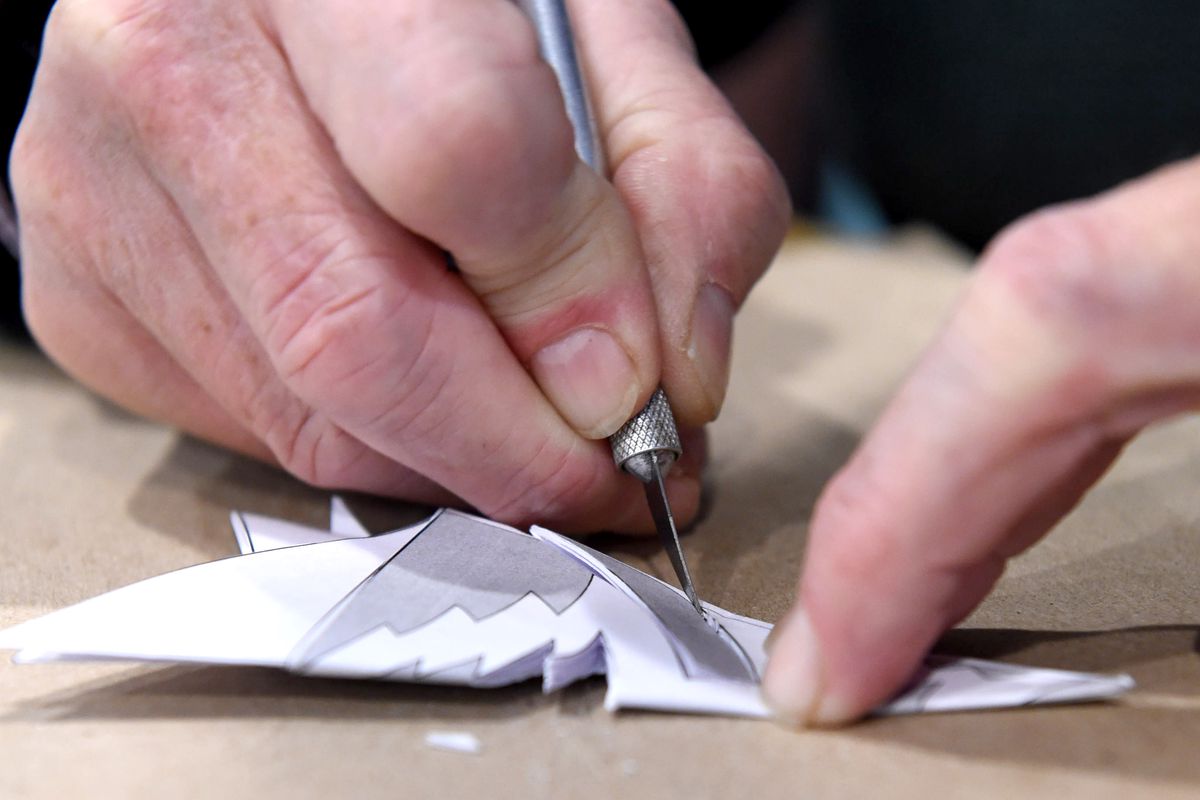 Howard Quaintance, principal emeritus, prepares a new snowflake by folding the paper and making the cuts with a x-acto blade through 12 layers of paper. Muhlenberg Greene Architects, Ltd., of Wyomissing, celebrated its 30-year tradition of
