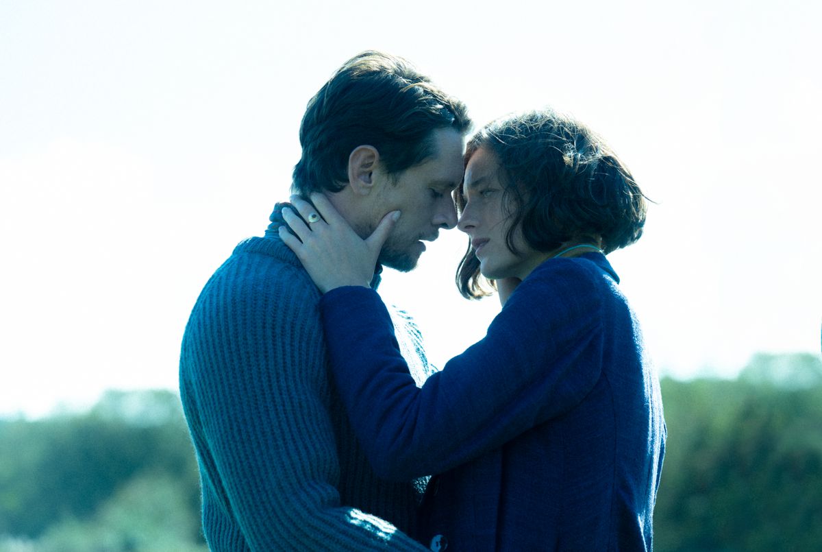 A man (Oliver O’Connell) and a woman (Emma Corrin) embracing one another.