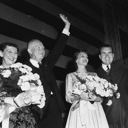 There are smiles all around as President Dwight D. Eisenhower and Vice President Richard Nixon acknowledge cheers of Republicans at election headquarters early November 7, 1956, as their bouquet-holding wives stand beside them. The Eisenhowers and the Nixons went before a jubilant crowd shortly after Adlai Stevenson conceded.