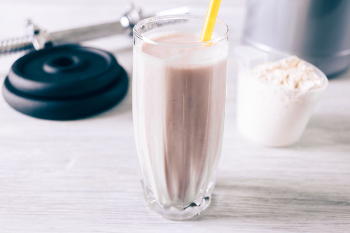A meal-replacement shake in a glass with a straw.