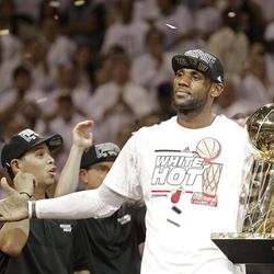 The Miami Heat's LeBron James holds the the Larry O'Brien NBA Championship Trophy after Game 7 of the NBA basketball championship against the San Antonio Spurs, Friday, June 21, 2013, in Miami. The Miami Heat defeated the San Antonio Spurs 95-88 to win their second straight NBA championship. 