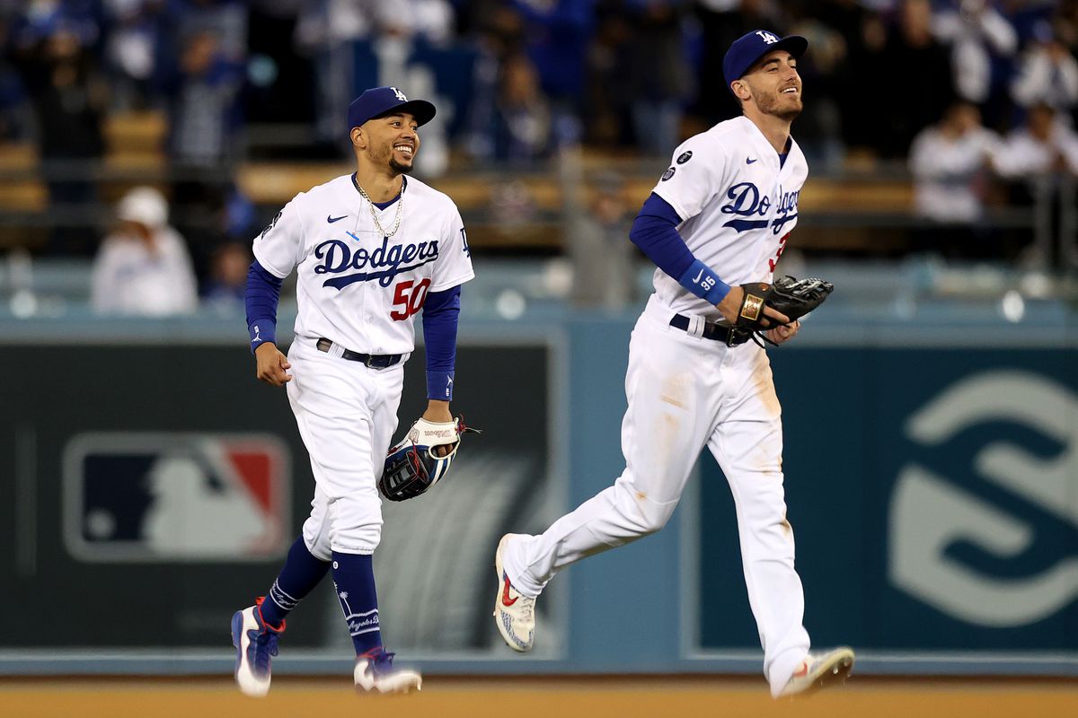 Cody Bellinger #35 and Mookie Betts #50 of the Los Angeles Dodgers react after beating the San Francisco Giants 7-2 in game 4 of the National League Division Series at Dodger Stadium on October 12, 2021 in Los Angeles, California.