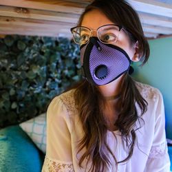 Sophie Weidmann, 13, sits on her bed with her air pollution mask on at her home in Salt Lake City on Thursday, Nov. 8, 2018.