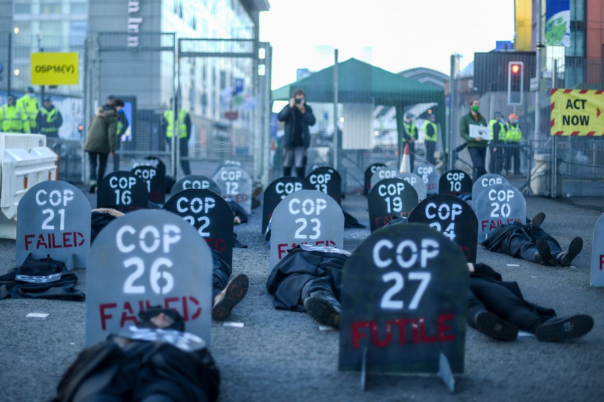 Extinction Rebellion protesters are seen during a die in protest outside the entrance to the COP26 site on November 13, 2021 in Glasgow, United Kingdom.