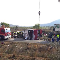 Emergency services personnel stand at the scene of a bus accident crashed on the AP7 highway that links Spain with France along the Mediterranean coast near Freginals halfway between Valencia and Barcelona early Sunday, Spain, March 20, 2016. The bus was reportedly hired out to carry students to and from a fireworks festival in Valencia and was on the return leg of its journey when the accident happened.