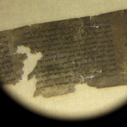 Conservators examine a portion of the Dead Sea Scrolls containing the ten commandments before the scrolls' installation at Discovery Times Square in New York, Thursday, Dec. 15, 2011. 