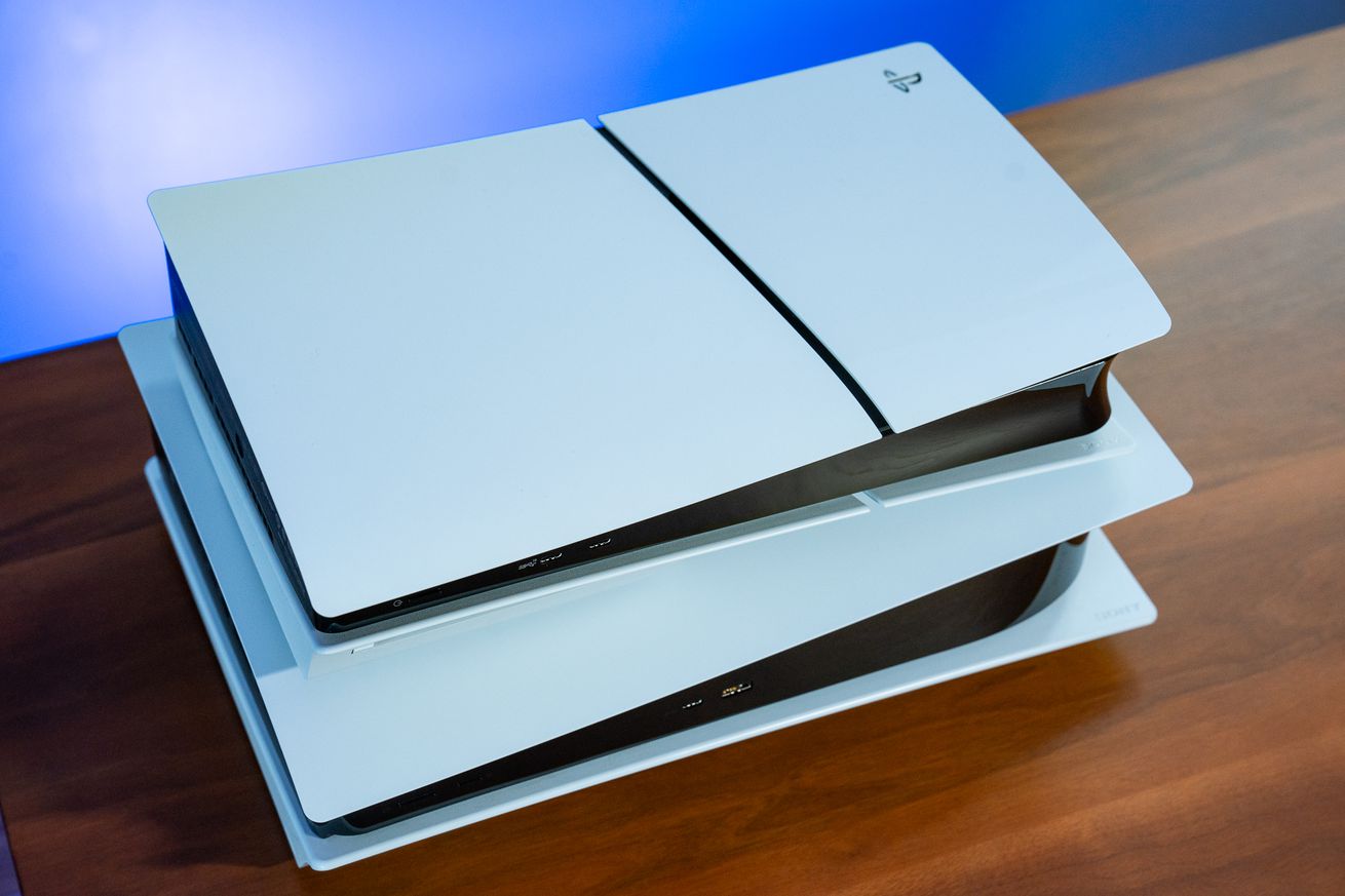 A PS5 Slim model resting atop a standard-sized PS5 console.