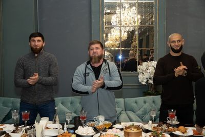 Ramzan Kadyrov flanked by UFC star Khamzat Chimaev and light-heavyweight contender Magomed Ankalaev at a banquet in Chechnya. 