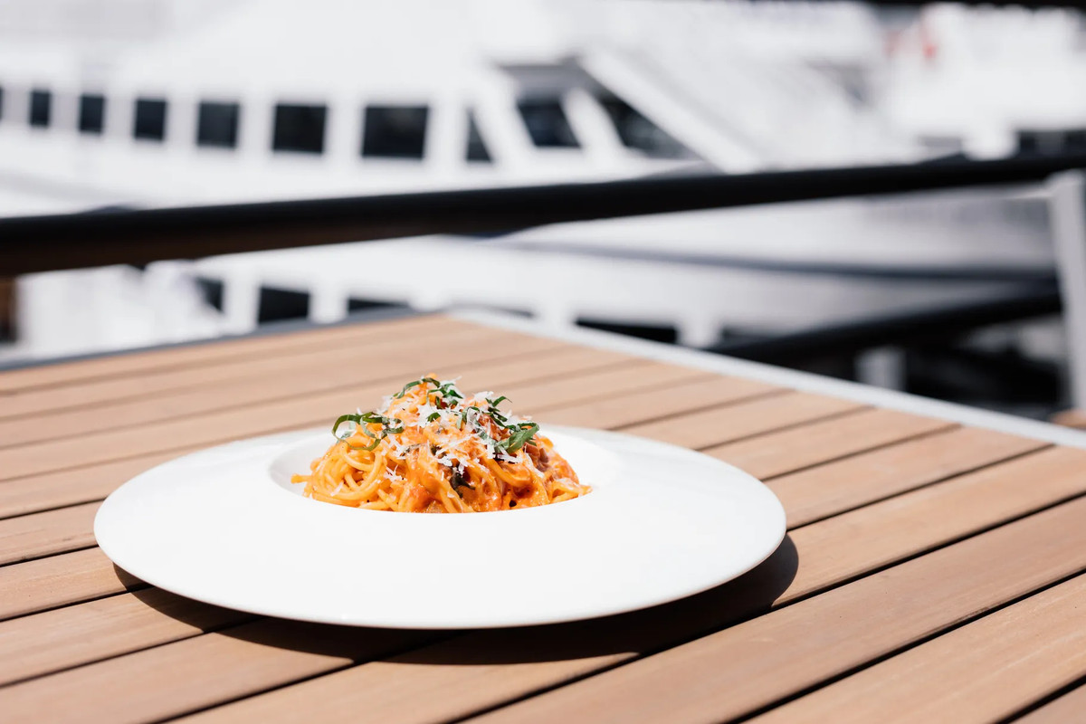A plate of pasta on an outdoor table.