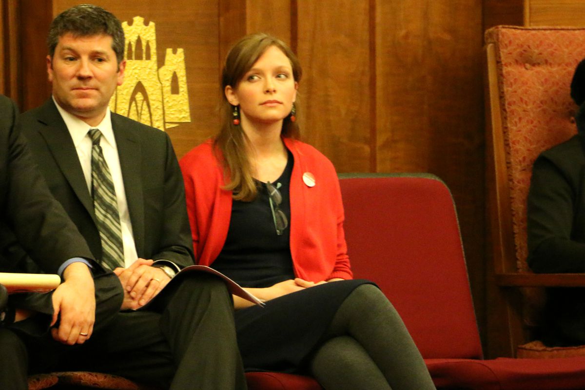 A man, left, and a woman, right, sit in red chairs.