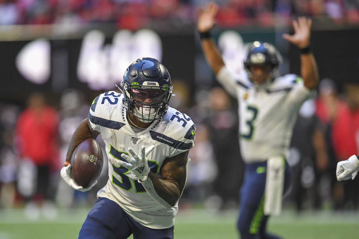 Seattle Seahawks running back Chris Carson scores a touchdown against the Atlanta Falcons as quarterback Russell Wilson reacts in the background during the first half at Mercedes-Benz Stadium.