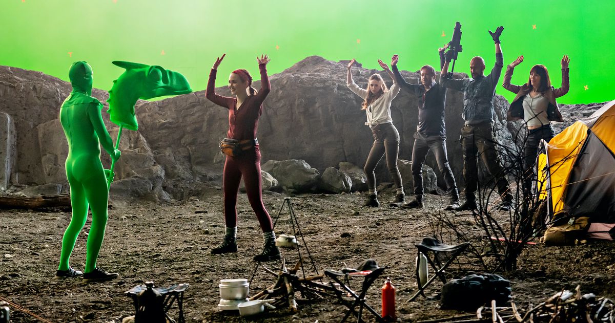 Iris Apatow, Karen Gillan, David Duchovny, Keegan-Michael Key, and Leslie Mann stand on the Cliff Beasts 6 set with their hands in the air, surrounded by fake rocks and greenscreens, in The Bubble