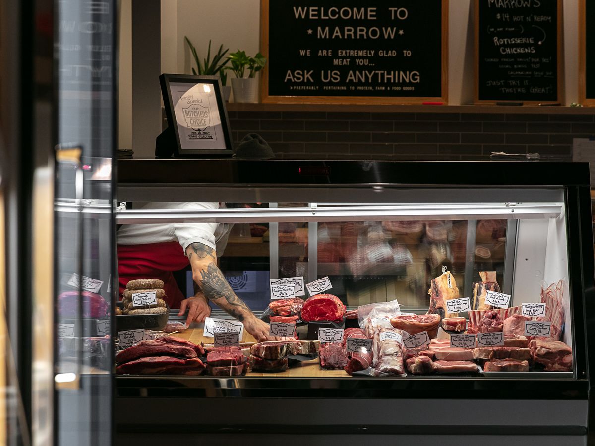 A tattooed arm reaches into the butcher case at Marrow.