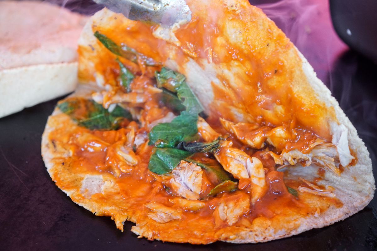 An exposed orange sauce inside a tortilla.