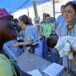 Dr. Lina Abujamra, of the Children's Memorial Hospital of Chicago, speaks to the mother of a dehydrated baby at a makeshift camp in the National Stadium in Port-au-Prince, Tuesday.