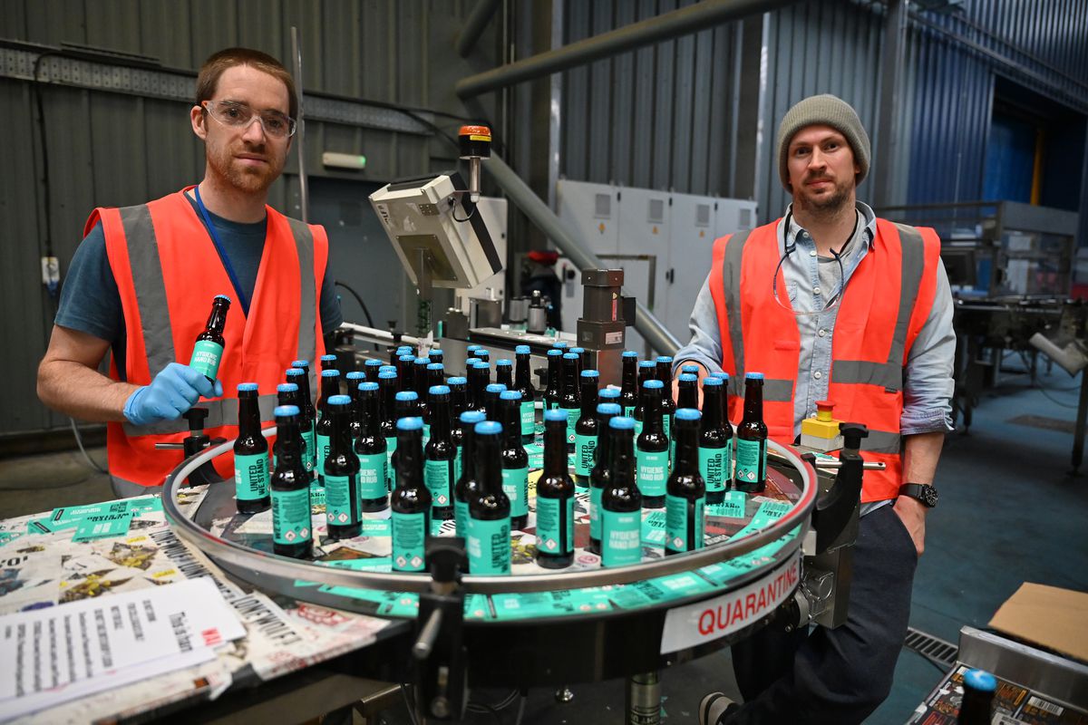 Brewdog co-founders Martin Dickie and James Watt pose with hand sanitiser in Brewdog bottles.