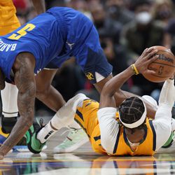 Utah Jazz guard Mike Conley, right, recovers a loose ball as Denver Nuggets forward Will Barton defends in the first half of an NBA basketball game Wednesday, Jan. 5, 2022, in Denver. 