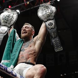 November 12, 2016 — Conor McGregor sits atop the cage after winning the lightweight title from Eddie Alvarez, making him the UFC’s first simultaneous champ-champ. 