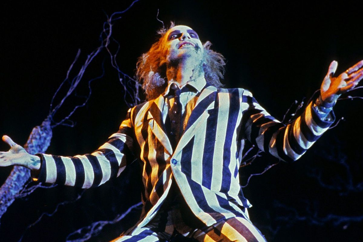 Michael Keaton as Beetlejuice with his arms outstretched