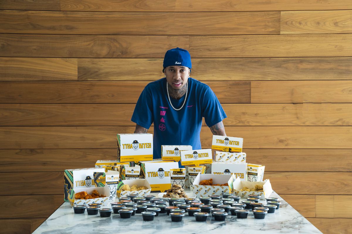 The rapper Tyga poses behind a table of Tyga Bites, the chicken nugget company he founded.