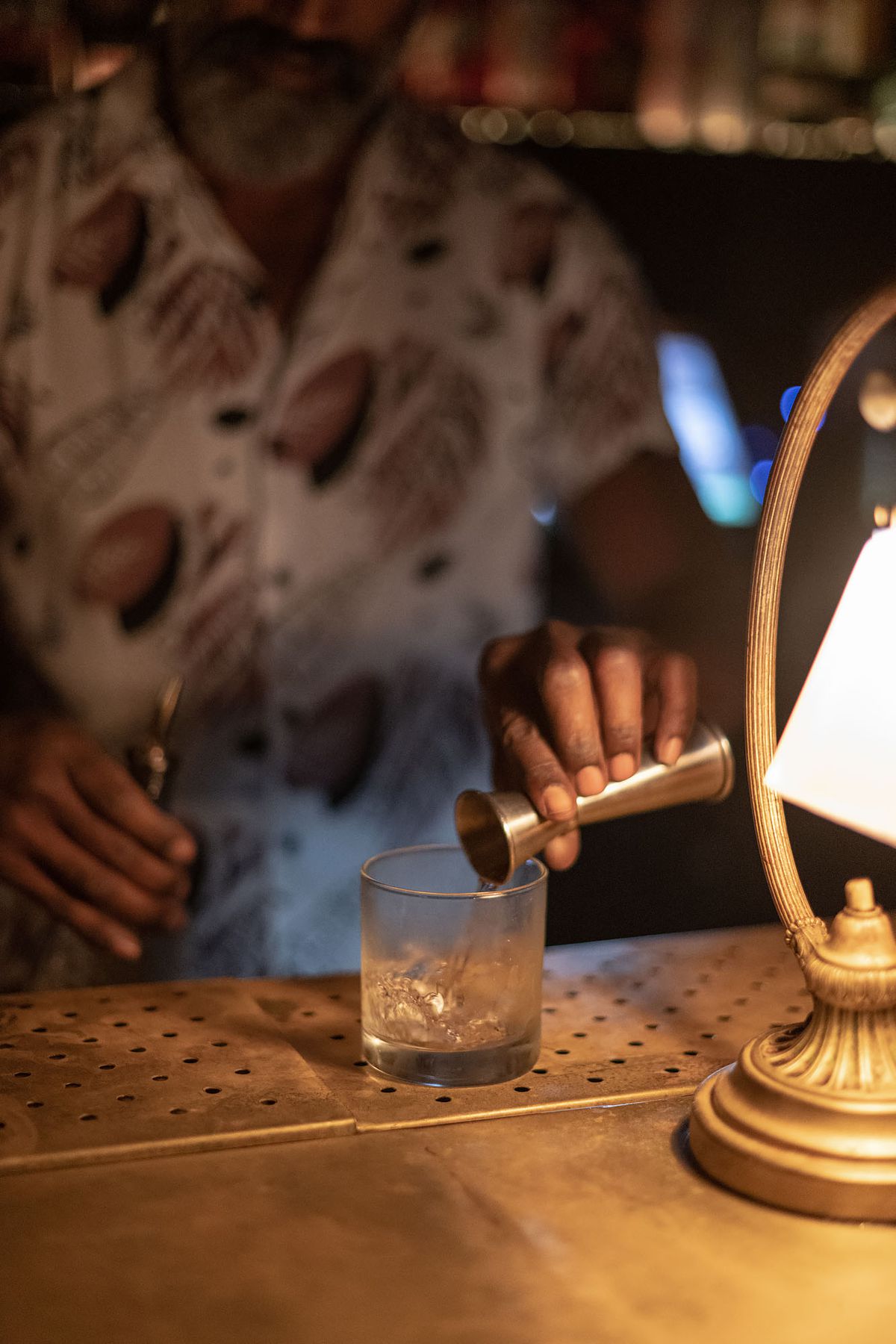 A bartender pours a spirit into a glass at Power House Bar.