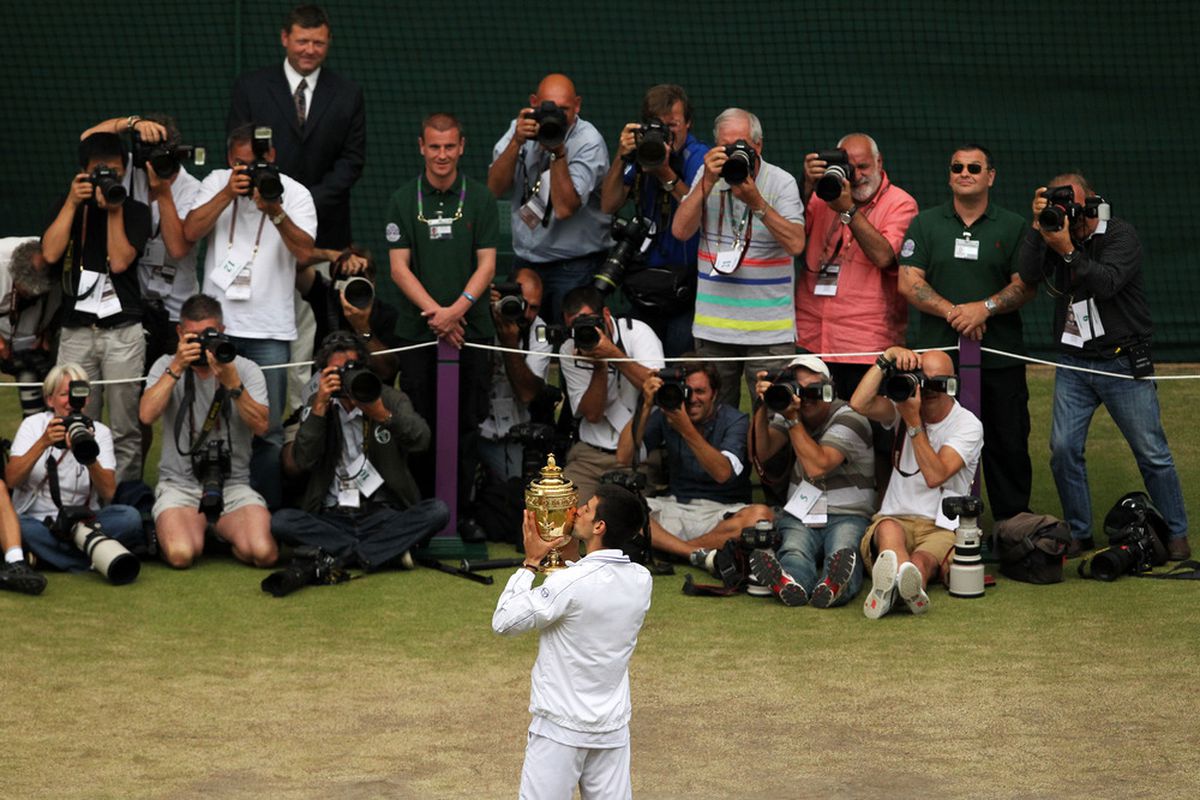 Novak Djokovic of Serbia kisses the championship trophy after winning at Wimbledon.