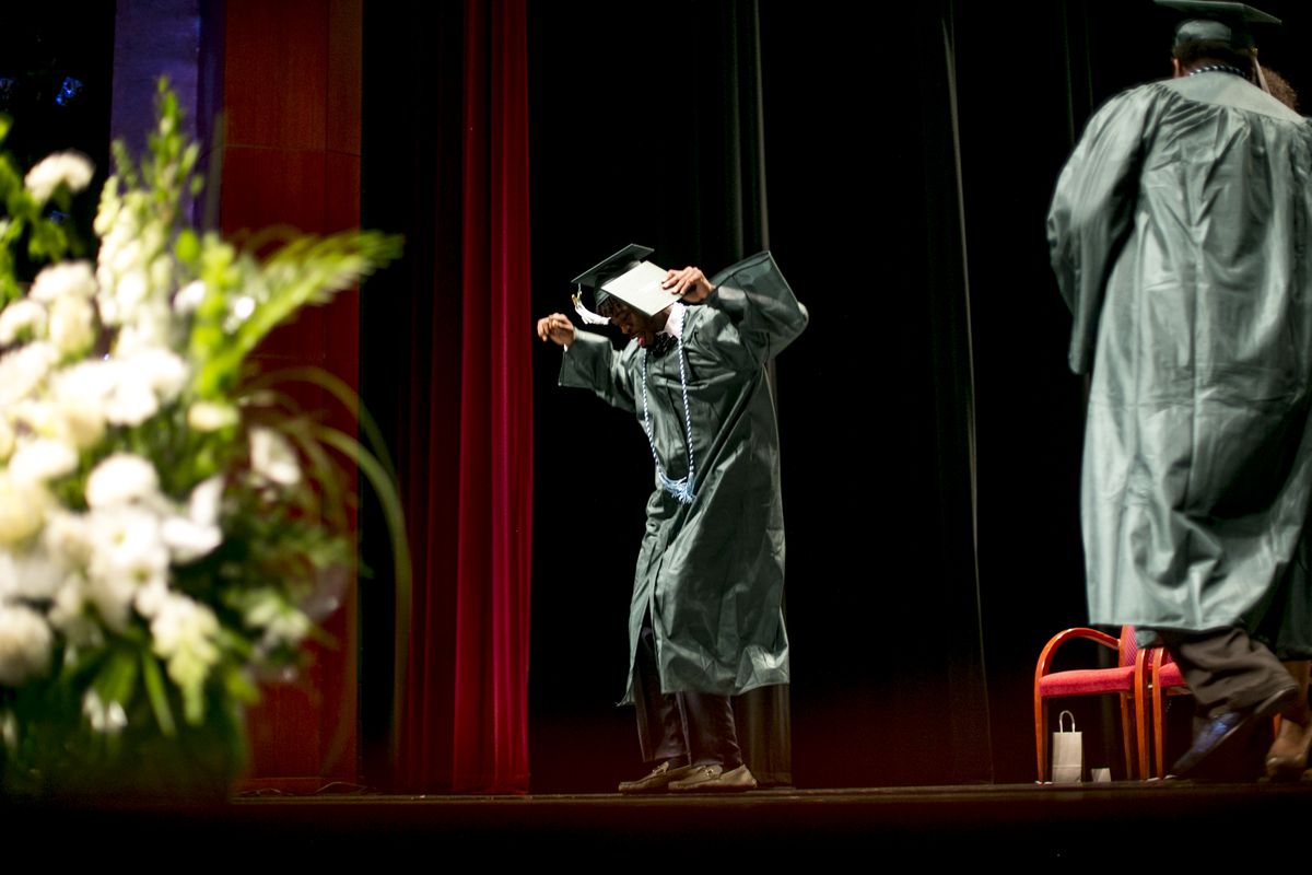Joseph Thomas does a dance while walking across the stage during the graduation ceremony for Cody High School in May.