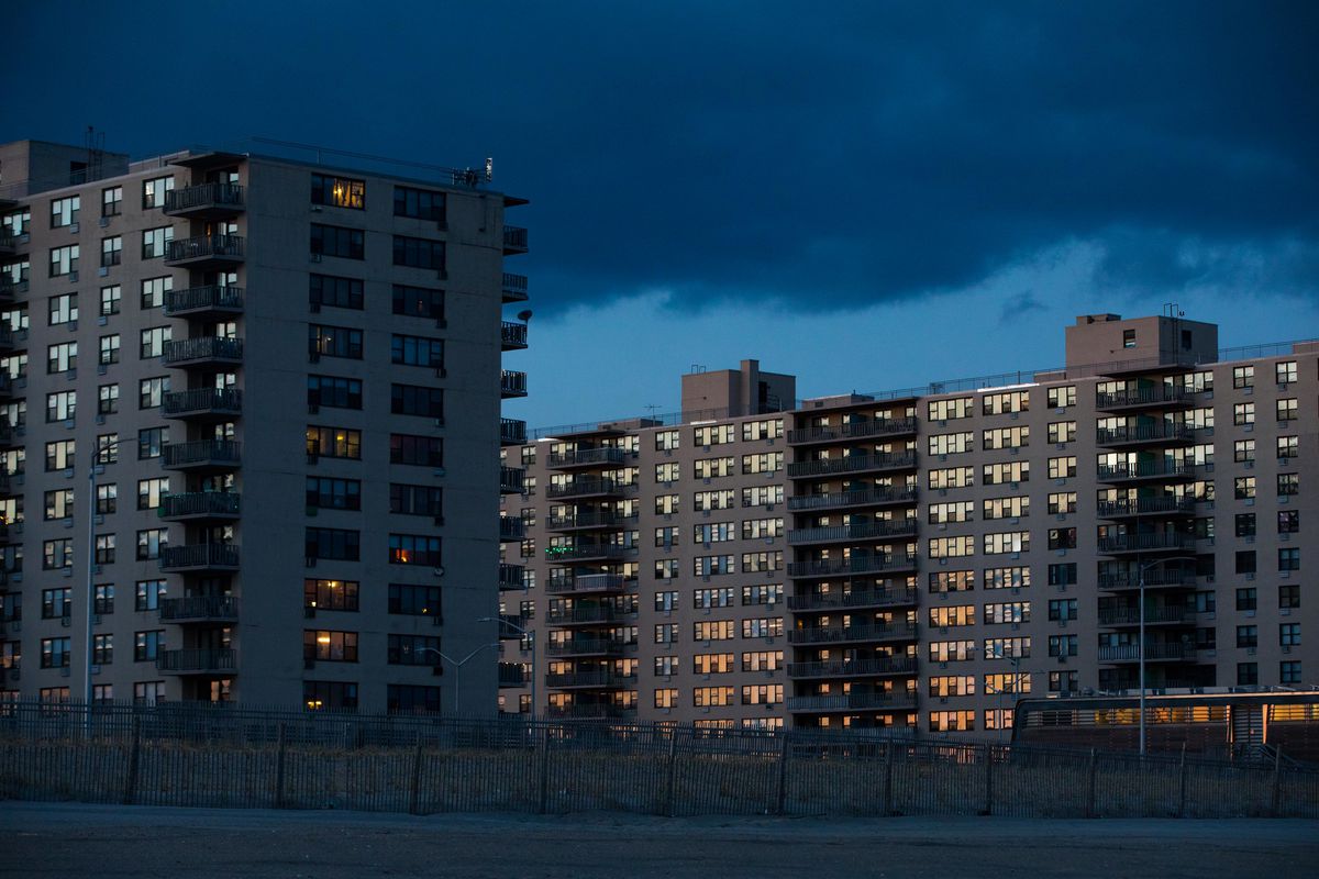 Three high-rise residential towers in Rockaway just off the beach. The setting sun reflects off the windows of the apartments.