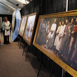 Volunteers look at paintings in the reception tent during the Ogden Utah Temple open house news media tour in Ogden, Tuesday, July 29, 2014.