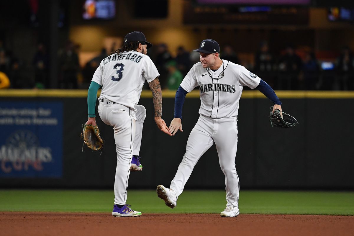 J.P. Crawford and Jarred Kelenic of the Seattle Mariners celebrate after the game against the Oakland Athletics at T-Mobile Park on September 29, 2021 in Seattle, Washington. The Mariners won 4-2.