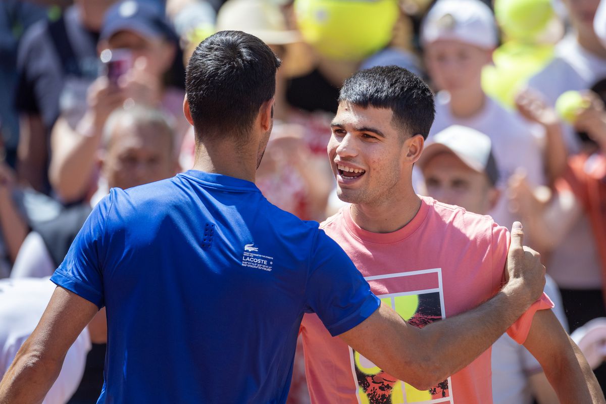 Novak Djokovic of Serbia and Carlos Alcaraz of Spain embrace as they change over practice sessions on Court&nbsp;Suzanne Lenglen in preparation for the 2023 French Open Tennis Tournament at Roland Garros on May 27, 2023, in Paris, France.