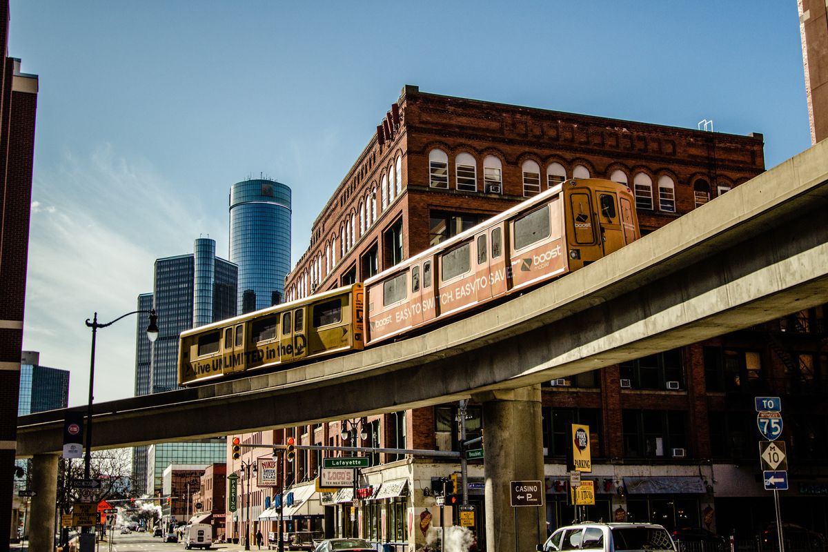 Detroit’s elevated people mover moves diagonally across a busy downtown street.