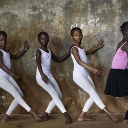 In this photo taken Friday, Dec. 9, 2016, young ballerinas practice under the instruction of Kenyan ballet dancer Joel Kioko, 16, in a room at a school in the Kibera slum of Nairobi, Kenya. In a country not usually associated with classical ballet, Kenya's most promising young ballet dancer Joel Kioko has come home for Christmas from his training in the United States, to dance a solo in The Nutcracker and teach holiday classes to aspiring dancers in Kibera, the Kenyan capital's largest slum. 