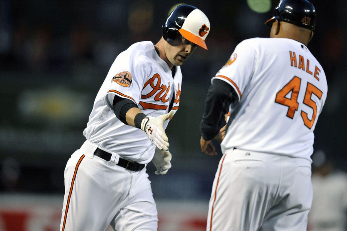 April 9, 2012; Baltimore, MD, USA; Baltimore Orioles catcher Matt Wieters (left) is congratulated by third base coach DeMarlo Hale (45) after hitting a solo home run in the second inning against the New York Yankees at Oriole Park at Camden Yards. 