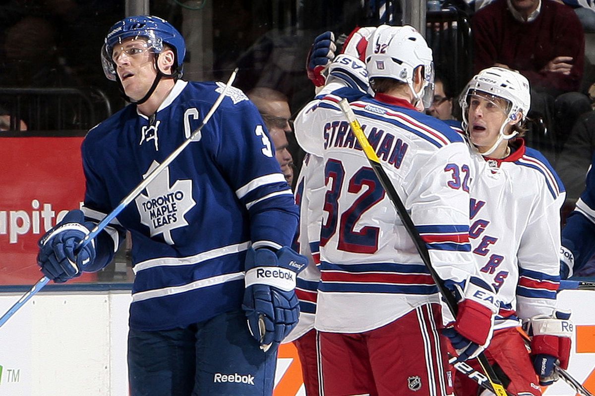 TORONTO - JANUARY 14: Dion Phaneuf #3 of the Toronto Maple Leafs skates off as the New York Rangers celebrate their 3rd goal  during NHL action at the Air Canada Centre January 14, 2012 in Toronto, Ontario, Canada. (Photo by Abelimages/Getty Images)