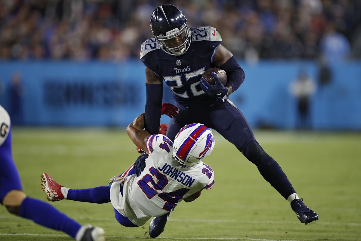Running back Derrick Henry #22 of the Tennessee Titans rushes in front of cornerback Taron Johnson #24 of the Buffalo Bills during the second half at Nissan Stadium on October 18, 2021 in Nashville, Tennessee.