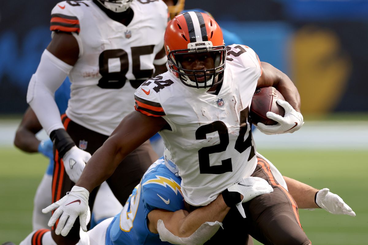 Nick Chubb #24 of the Cleveland Browns runs as he is tackled by Drue Tranquill #49 of the Los Angeles Chargers during a 49-42 loss to the Los Angeles Chargers at SoFi Stadium on October 10, 2021 in Inglewood, California.