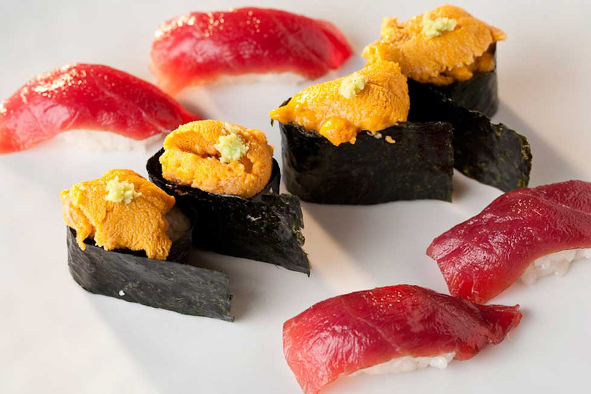 Four pieces of sushi topped with uni surrounded by four tuna nigiri.