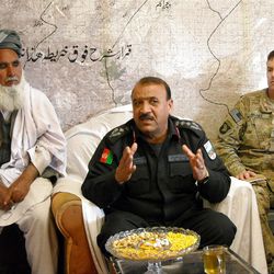 In this March 26, 2013, photo, an Afghan police commander explains to local tribal elders how the Afghan security forces intend to search the elders? villages for insurgents, with an elder accompanying each police team, hours after a combined force of Afghans and Americans encircled the town in a pre-dawn raid. U.S. Brigade commander Col. Joseph "J.P." McGee, of the U.S. Army?s 1st Brigade Combat Team, 101st Airborne Division, listens at right, at the Afghan army base next to Forward Operating Base Connolly, in Khogyani district, Nangarhar province, east of Kabul, Afghanistan. U.S. commanders trying to hand off war-fighting responsibility by the end of 2014 are encouraged by the uneven yet steady progress of fledgling Afghan security forces. (AP Photo/Kim Dozier)