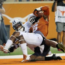 Texas' Quandre Diggs makes an interception in the end zone behind BYU's Terenn Houk as BYU and Texas play Saturday, Sept. 6, 2014, in Austin, Texas.