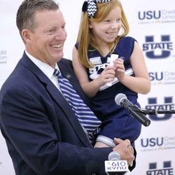 John Hartwell holds his daughter Lauren Hartwell as he speaks at a press conference where he was introduced as Utah State University's new Director of Athletics on Wednesday. Lauren wrote her own speech announcing from the podium that she was happy to be an Aggie. 