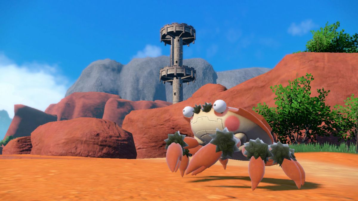 Klawf on the beach with a tower in the background. A screenshot from Pokémon Scarlet and Violet.
