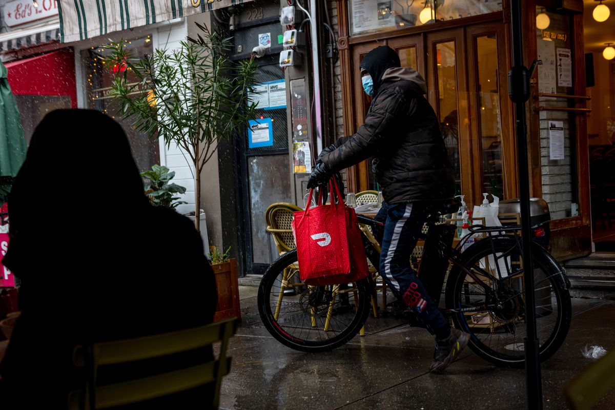 A DoorDash delivery driver riding a bicycle picks up food from Jack’s Wife Freda in New York City.