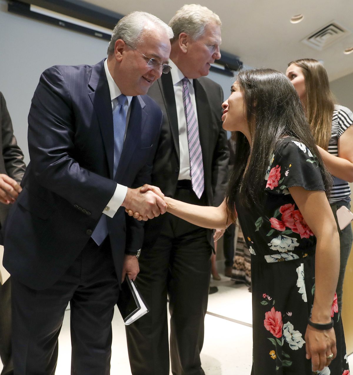 Elder Jack Gerard, a General Authority Seventy of The Church of Jesus Christ of Latter-day Saints, left, shakes hands with Enedina Stanger, a patient representative, after a broad coalition of Utah community leaders announced its opposition to Utah's medi