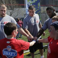 NFL draft prospects Eric Fisher of Central Michigan, center, Lane Johnson of Oklahoma, left, and Sharrif Floyd of Florida participate in a youth football clinic in New York, Wednesday, April 24, 2013.The draft begins Thursday in New York. 