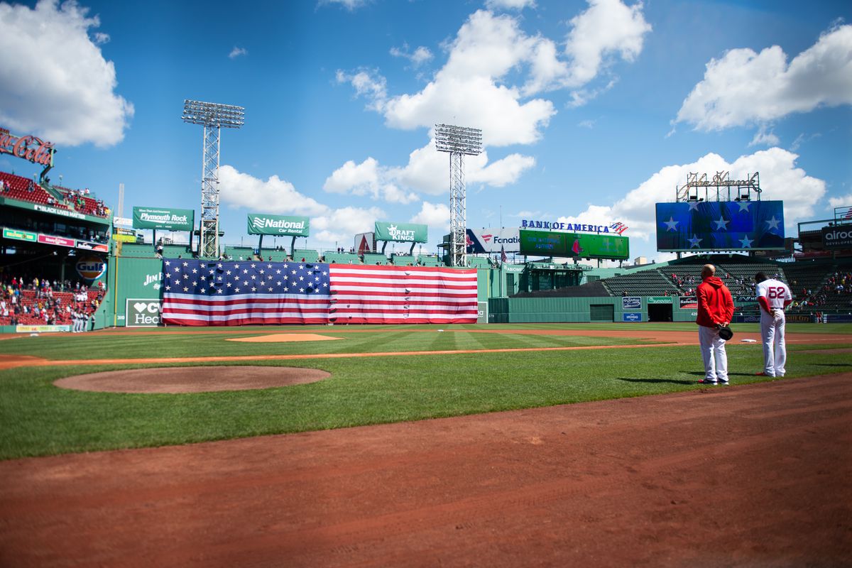 An American flag is dropped from the Green Monster prior to the start of the game between the Chicago White Sox and Boston Red Sox in honor of Patriots Day at Fenway Park on April 19, 2021 in Boston, Massachusetts.