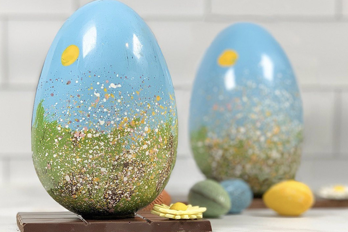 Two light blue painted chocolate Easter eggs with an artistic design
