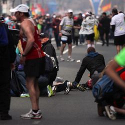 In this photo provided by The Daily Free Press and Kenshin Okubo, people react to an explosion at the 2013 Boston Marathon in Boston, Monday, April 15, 2013. Two explosions shattered the euphoria of the Boston Marathon finish line on Monday, sending authorities out on the course to carry off the injured while the stragglers were rerouted away from the smoking site of the blasts. 