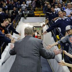 Head Coach Stew Morrill of Utah State is greeted by fans as he leaves the court following NCAA basketball against UNLV in Logan, Tuesday, Feb. 24, 2015.